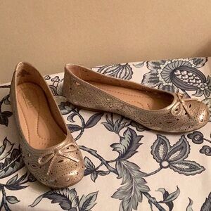 Brand new, never worn gold flats with a little sparkle, cutouts & bows! Too big!